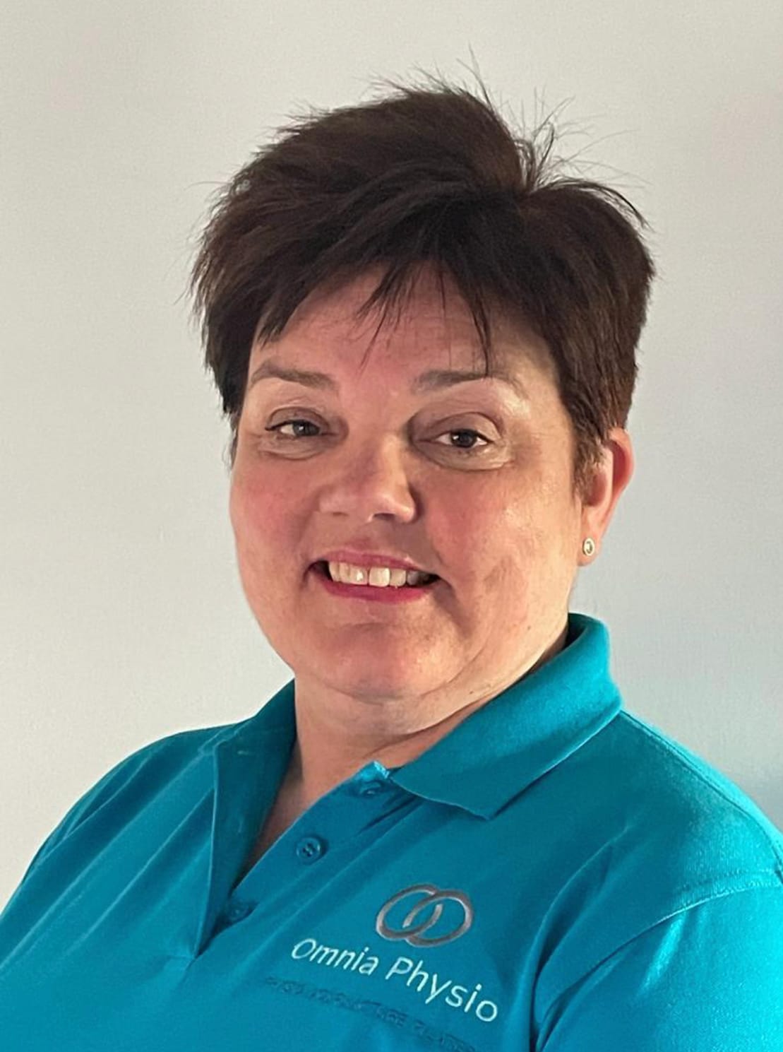 Smiling woman in Omnia Physio polo shirt