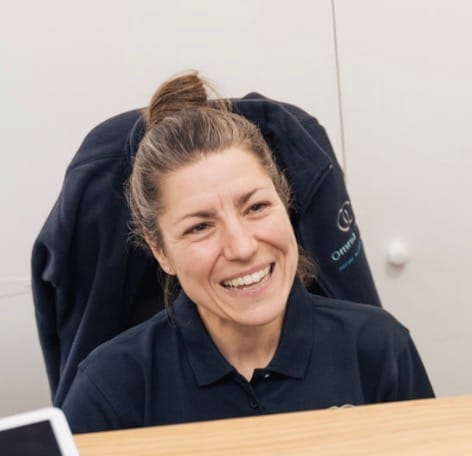 Smiling woman in navy polo shirt at desk