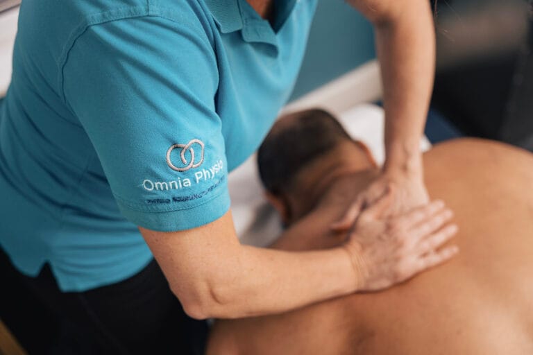 Physiotherapist providing back massage treatment to patient