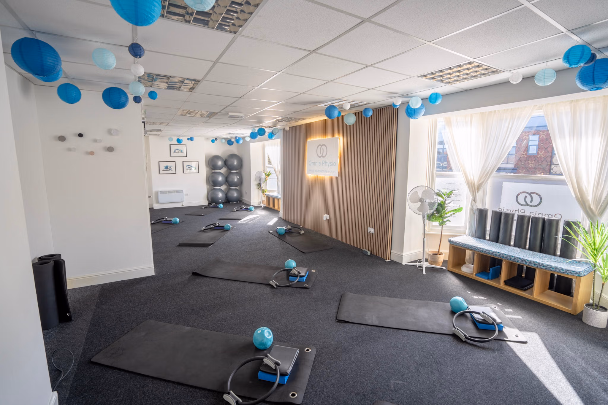 Bright physiotherapy studio with mats and exercise equipment
