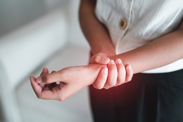 Person clutching painful wrist with both hands