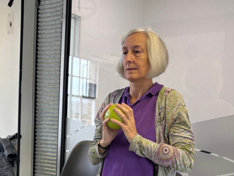 Woman holding a green apple in an office