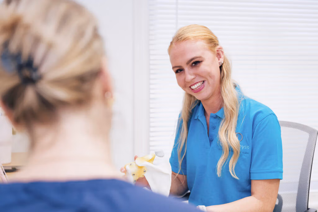 Physiotherapist discussing a spine model with a patient