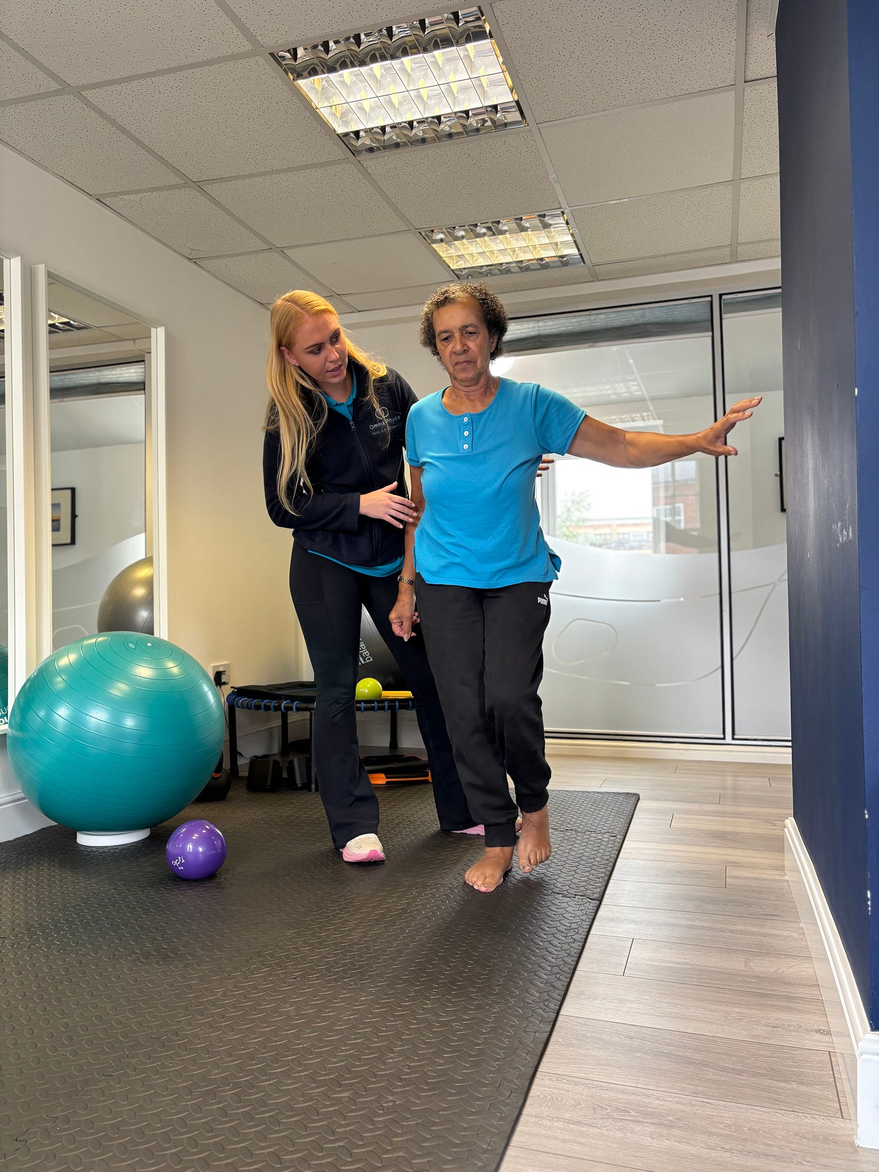 An Omnia physiotherapist supporting a client during a balance exercise